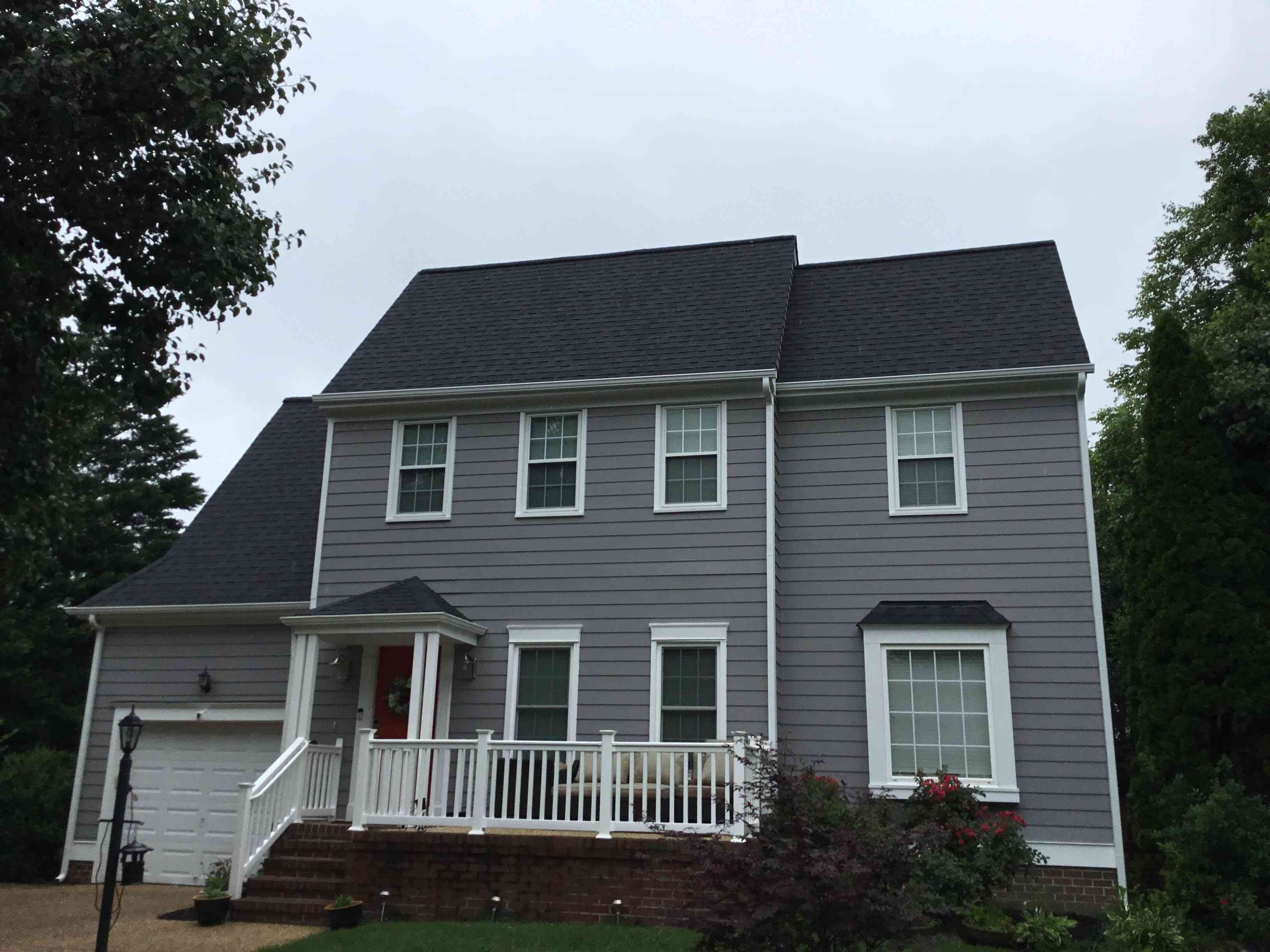 Two story house with a garage and a new black roof